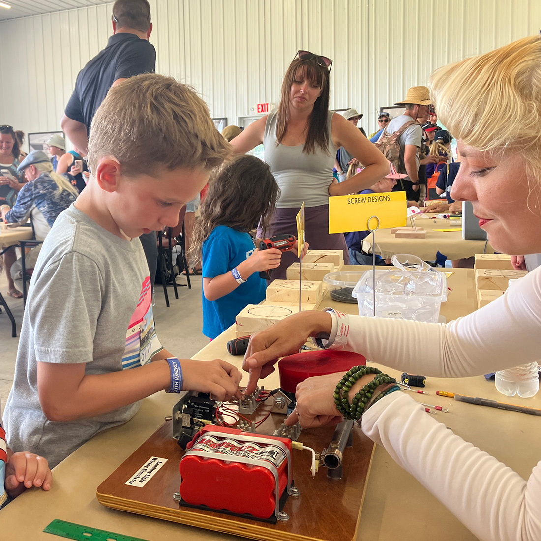 child doing an project at a table with an adult