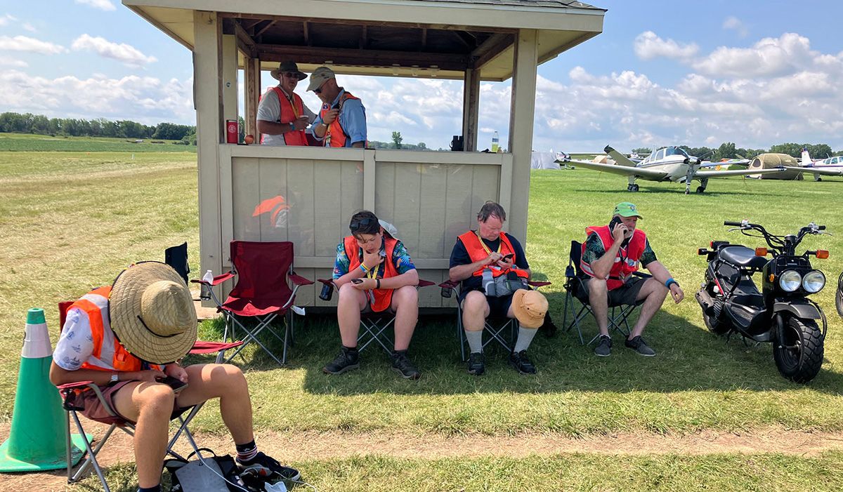 bunch of volunteers sitting looking a their phones