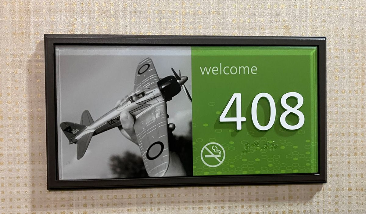 sign on door at elko hotel showing toy airplane on sign with room number